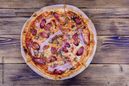 Pizza with salami sausage and parmesan cheese on a wooden table. Top view #520772776