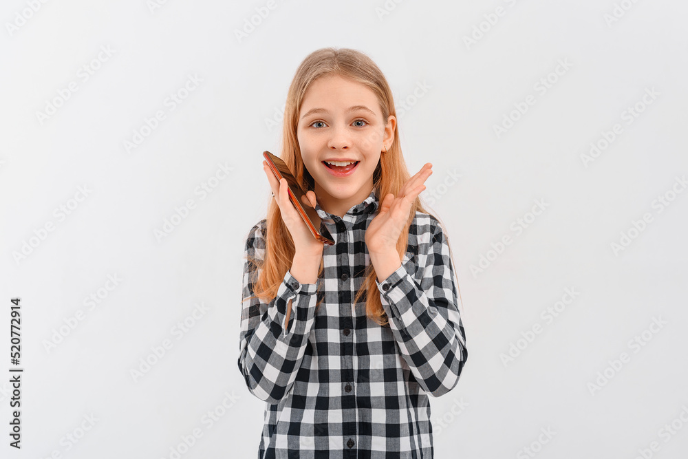 Portrait of smiling modern teen girl talking on mobile phone, thinking while on call, standing over white background Portrait of smiling modern teen girl talking on mobile phone, thinking while on call, standing over white background