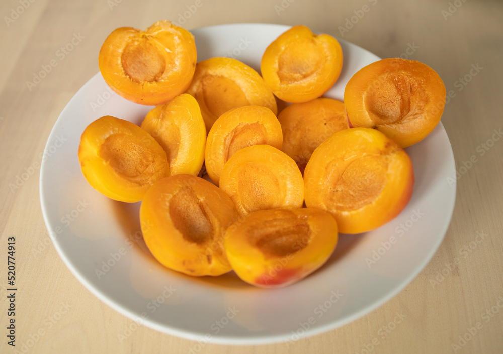 ripe, juicy apricots lie on a white plate. Energy boost, vitamins, ripe fruits, pesticides. Interruptions in the supply of fruits, imports of apricots