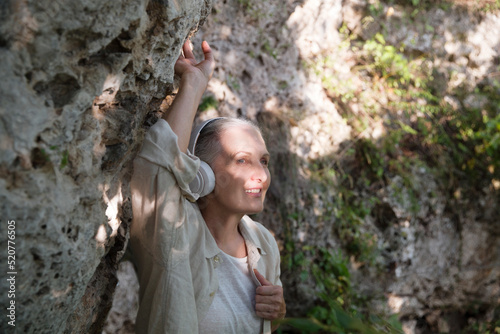 Summer lifestyle portrait senior woman in headphones relax on the outdoor. Enjoying the little things. spends time in nature in summer. Audio healing. meditation.
