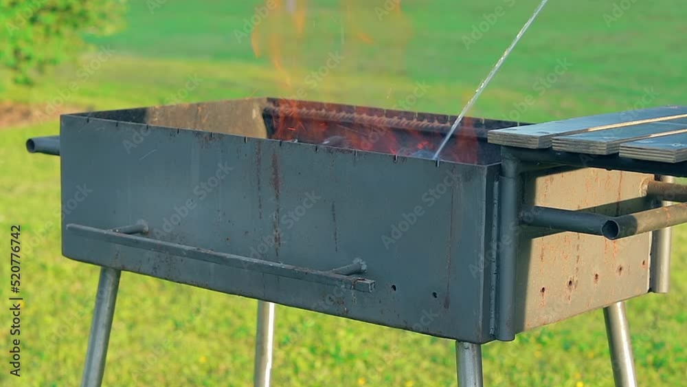 Burning Fire with Smoke Inside the Empty Brazier in Summer in the Daytime Outdoors. Preparing for Barbecue Cooking or Kebab Grilling. Kindling Coals in the Mangal - Static Shot, Slow Motion