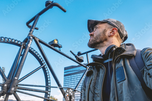 A man looks at a large sculpture of a bicycle photo