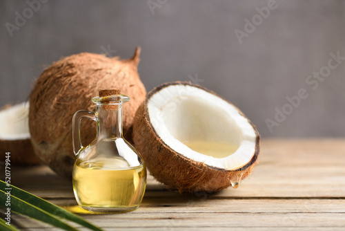Fotografia Virgin coconut oil with coconut fruits on wooden table.