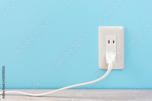 white electric outlet mounted on light blue wall. 水色の壁に取り付けられた白いコンセント	