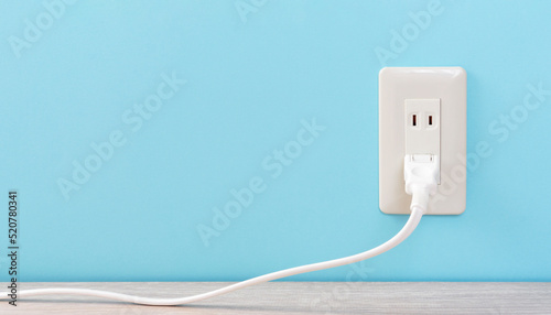 white electric outlet mounted on light blue wall. 水色の壁に取り付けられた白いコンセント	