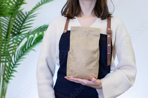 barista woman holding coffee bean packaging