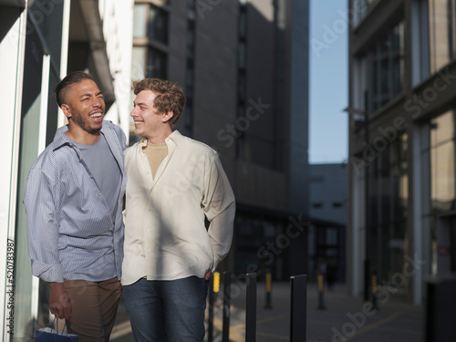 UK, South Yorkshire, Smiling gay couple walking in city
