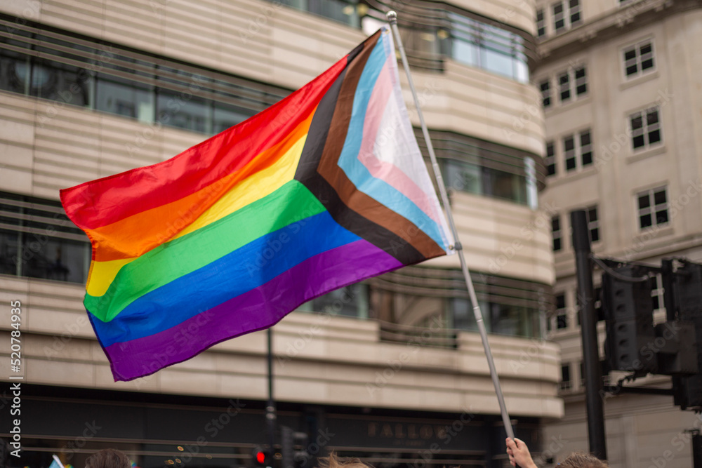 LGBT parade, person holding progress pride flag - obrazy, fototapety, plakaty 