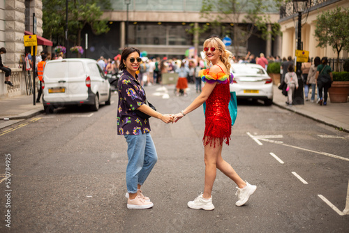 Two women at LGBT parade, looking at camera