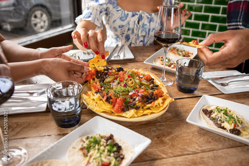 Photography UK, London, Close-up of friends enjoying Mexican food at restaurant table