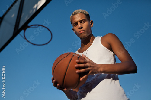 Black sportsman with basketball on sports ground © Juan