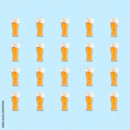 Pattern of large beer glass full of beer with foam on blue background.
