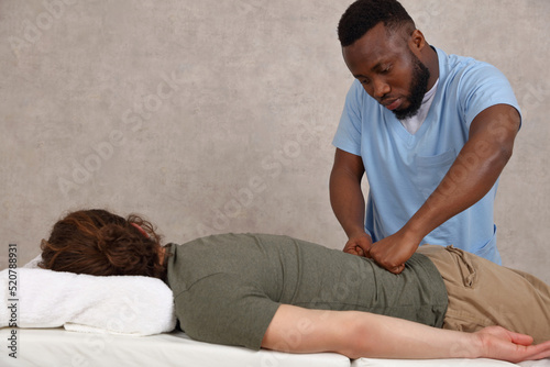Chiropractor and Patient suffering from Back pain. Physiotherapy, Sport Injury Rehabilitation concept
