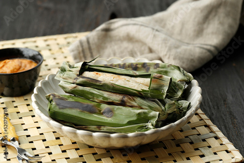 Roasted Otak otak, Indonesian Fish Cake Wrapped with Banana Leaf and Grill. Served with Peanut SAuce or Sweet and Savory Red Spicy Sauce photo