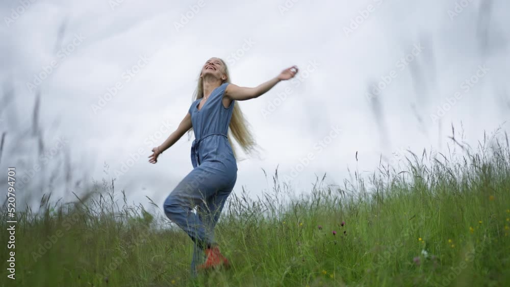 Happy teenage girl dancing at meadow in rain. Smiling and enjoying rainy weather. Happy teenage girl dancing at meadow in rain. Smiling and enjoying rainy weather.