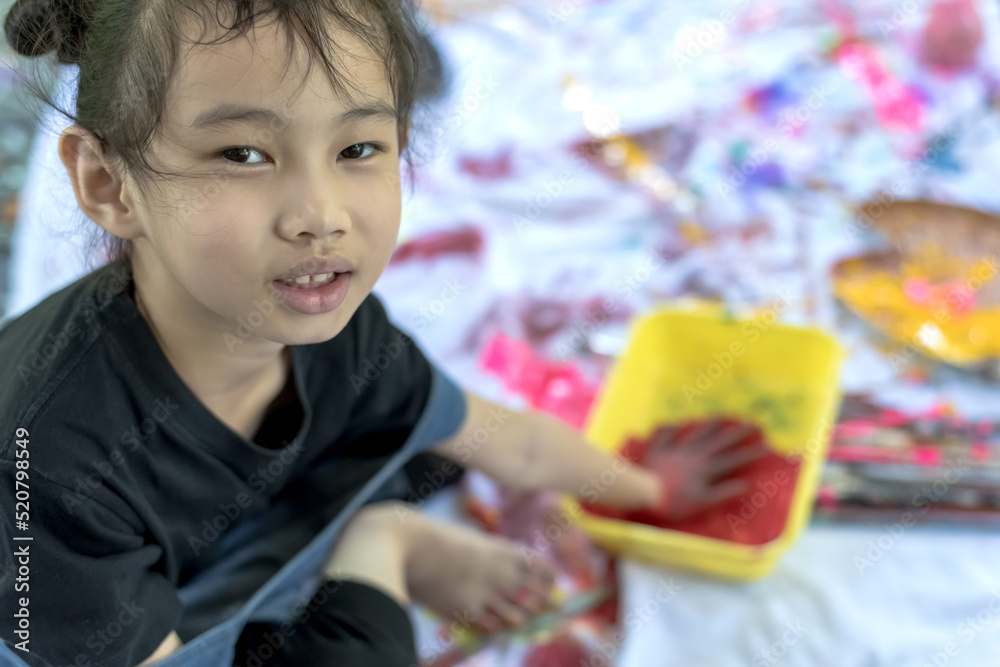 Little asian artist girl having fun playing with colored painting tray in art school, Kids Artist