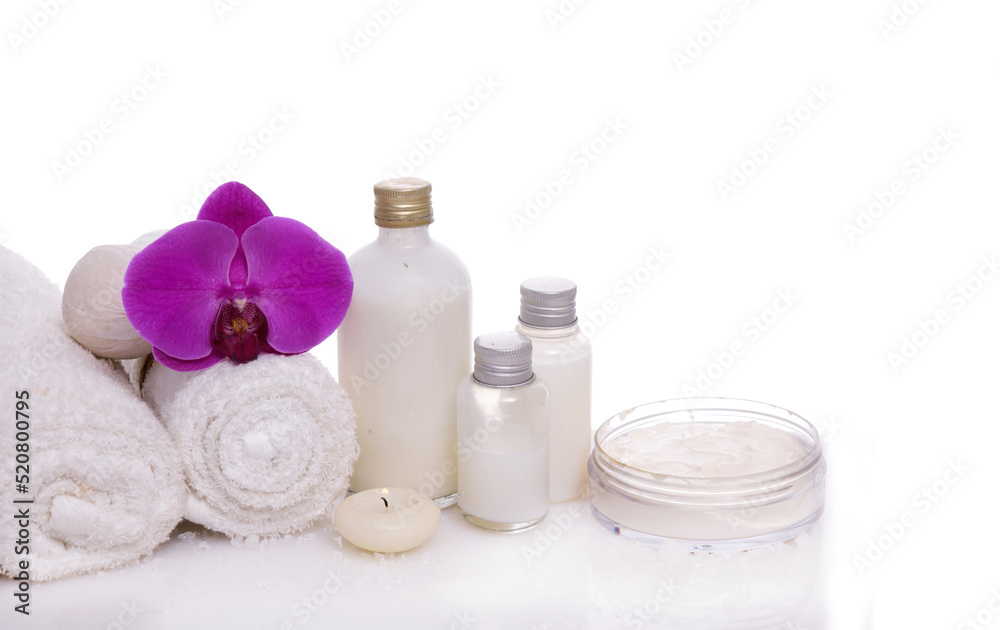 Spa setting with bottles of essential oil , herbal ,ball, candle , rolled towel, orchid Spa setting with bottles of essential oil , herbal ,ball, candle , rolled towel, orchid