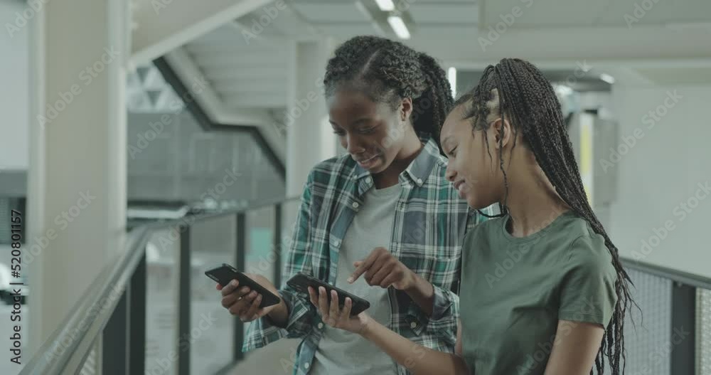 Female High School Students Looking at Smartphone in Break Female High School Students Looking at Smartphone in Break