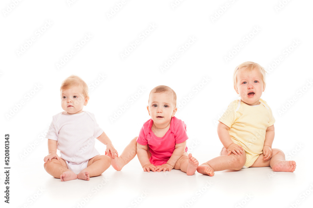 Three babies sitting isolated on a white Three babies sitting isolated on a white