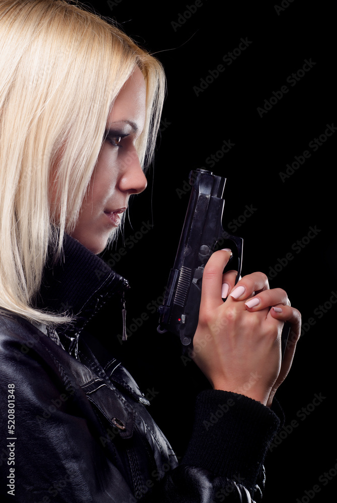 Young woman shooting with gun isolated on black background Young woman shooting with gun isolated on black background