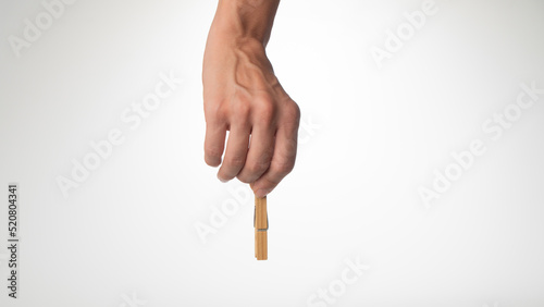 Tableau sur toile A woman's hand holds a wooden clothespin to secure the paper