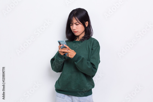 mad and shock young asian beautiful woman using mobile phone isolated on white background
