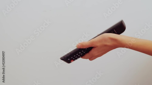 close-up women's hands try to turn on the TV, but they can't do it and they hit it because the remote switch doesn't work