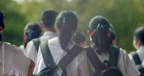 Slow motion back view of the Asian high school students in white uniform are going back to school when school starts.	