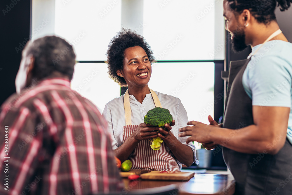 Happy multigenerational african american family make dinner together.