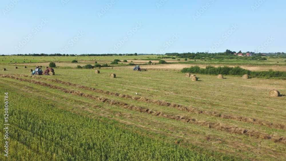 Tractor collecting and baling hay Tractor collecting and baling hay