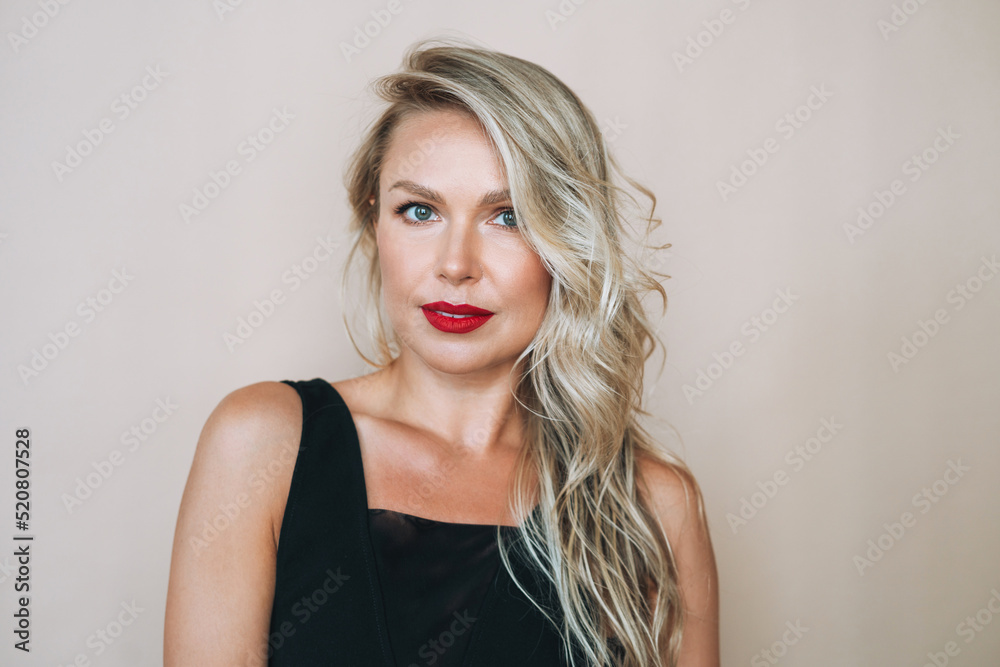 Portrait of gorgeous beautiful blonde young woman with bright makeup in evening dress on beige background Portrait of gorgeous beautiful blonde young woman with bright makeup in evening dress on beige background