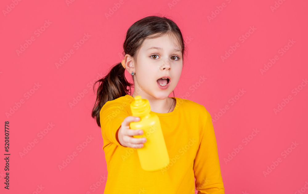 amazed kid hold water bottle on pink background amazed kid hold water bottle on pink background