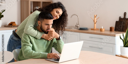 Young couple using laptop i...