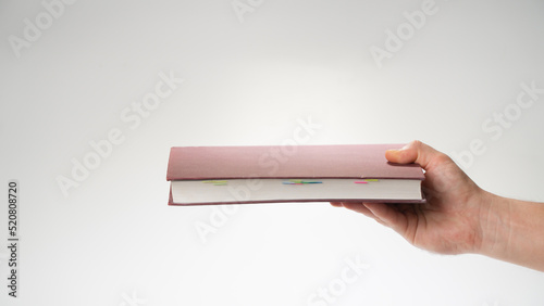 Hand holds the book in a horizontal position on a white background gesture