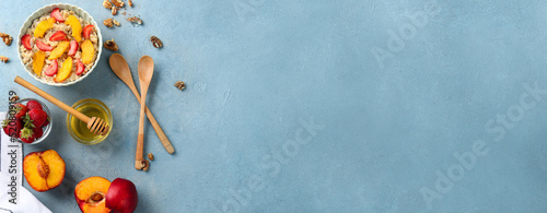 Composition with tasty oatmeal and fruits on light blue background with space for text