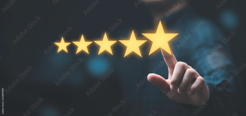 Businessman touching glowing yellow five stars for excellent evaluate after customer use product service , ISO and quality standard certificate concept. - obrazy, fototapety, plakaty 