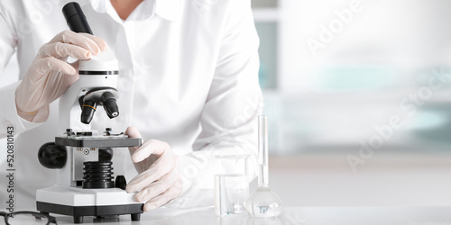 Scientist using microscope ...
