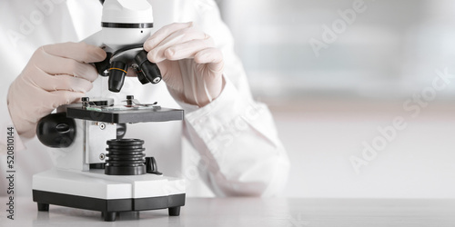 Scientist using microscope ...