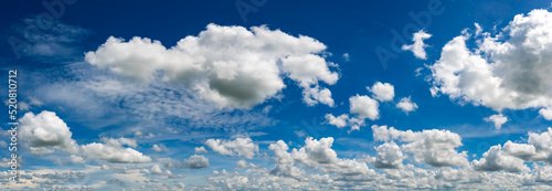 Panoramic vivid blue sky with white clouds.Panorama Sunlight with blue sky on dark background.Vivid sky on white cloud. © noon@photo