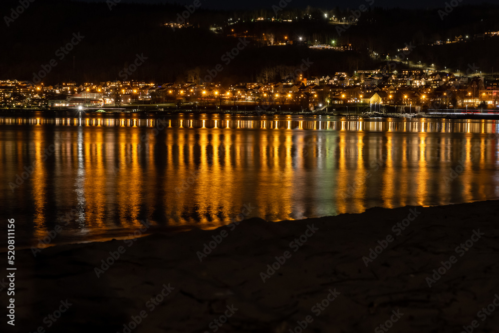 Lights from a hillside town reflect in a lake at night Lights from a hillside town reflect in a lake at night