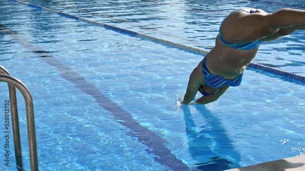 Side view of woman diving in water while resting at pool in sunny day.