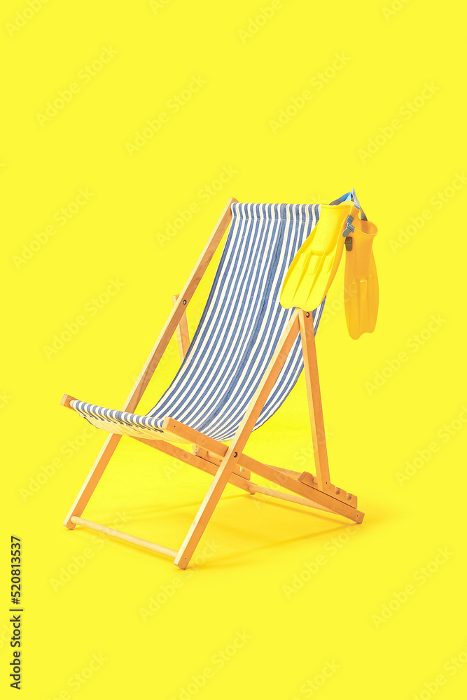 Wooden deck chair with paddles on yellow background