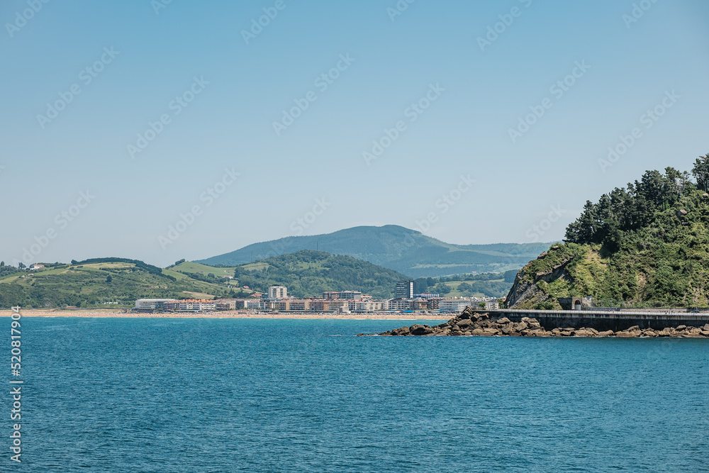 Scenery of coastal city against mountains in summer Scenery of coastal city against mountains in summer