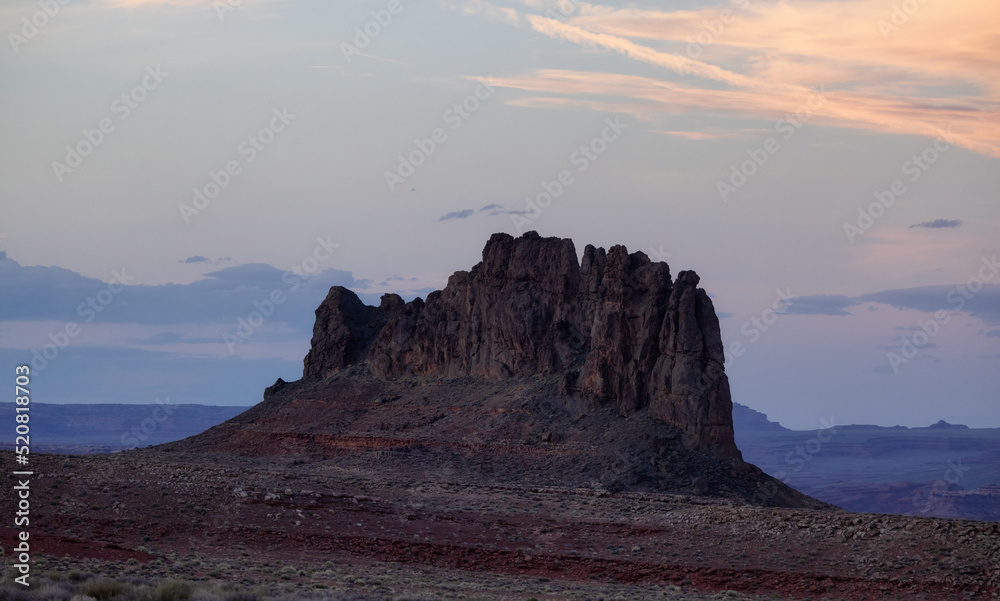 Red Rock Mountain Landscape during colorful sunset sky. Alhambra Rock near Mexican Hat, Utah, United States. American Nature Background
