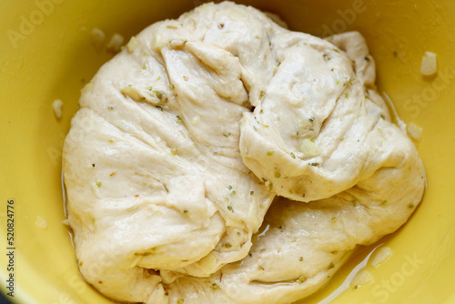 Dough mixed with chopped garlic and herb after Kneaded in a mixing bowl photo