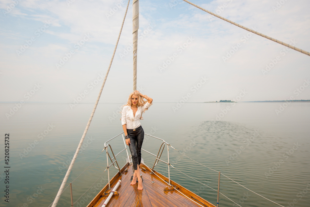 Naklejka premium girl posing on a yacht.portrait of a sporty girl on a yacht