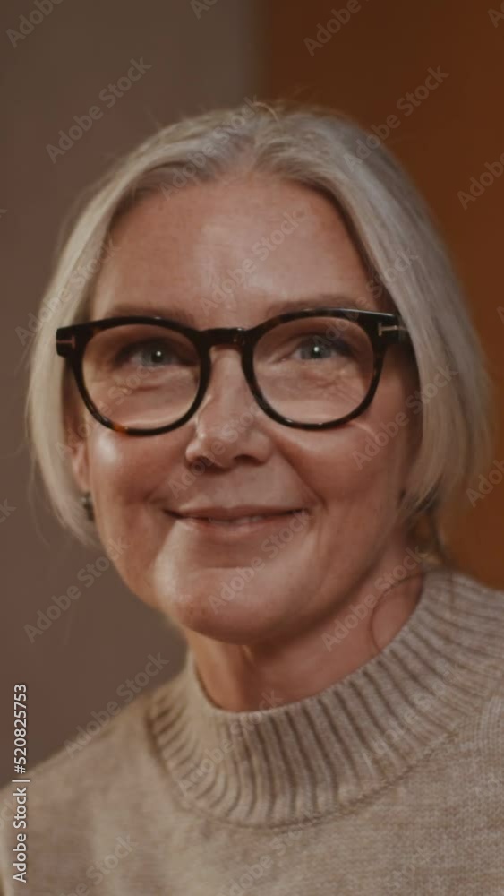 A woman smiling looks directly at the camera, sitting at a laid festive table