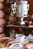 White mug with tea and saucer on a wooden table.  The concept of Russian tea drinking with pies and a samovar.