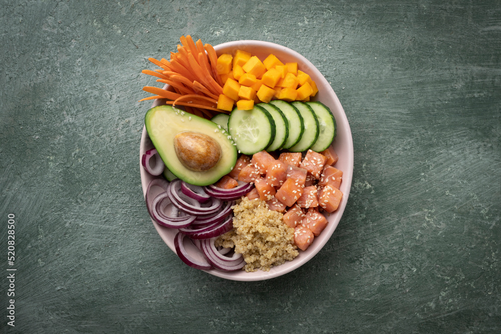 Poke bowl with quinoa and salmon and raw vegetables, healthy food bowl, top view Poke bowl with quinoa and salmon and raw vegetables, healthy food bowl, top view