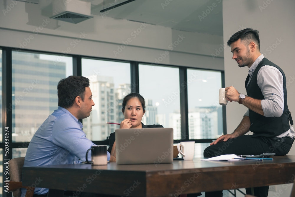 businessman and woman discussing about a meeting at office space. Three business people use computer laptop and talking together at office indoor.
